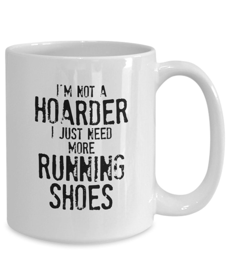 May include: White ceramic coffee mug with black text that reads "I'm not a hoarder I just need more running shoes".