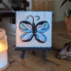 Butterfly made using paper quilling on a 4x4 wooden plank and comes with the easel