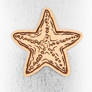 May include: A wooden cutout of a starfish with a brown outline and a light brown interior. The starfish has a detailed design of small circles and lines.