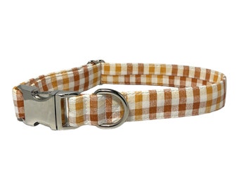 May include: A brown and white checkered dog collar with a silver buckle and D-ring.