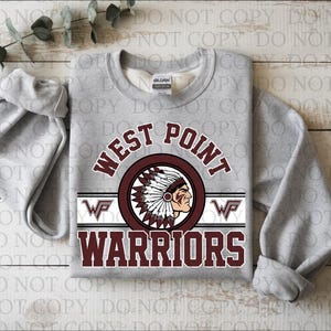 Puede incluir: Una sudadera gris jaspeado con las palabras "WEST POINT WARRIORS" en letras granates y blancas. El diseño incluye una cabeza de jefe nativo americano en un emblema circular. La sudadera tiene mangas largas.