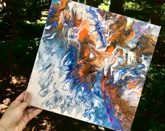 May include: Abstract painting on canvas with swirling blue, white, orange, and purple paint. The colors blend together to create a unique and dynamic design.