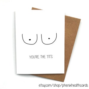 May include: A white greeting card with a minimalist illustration of two breasts and the phrase "YOU'RE THE TITS" in black text. The card is paired with a brown envelope.