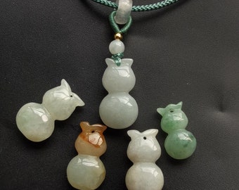 May include: Five jade gourd pendants of varying sizes and colors, including green, white, and brown. The pendants are strung on a green cord necklace.