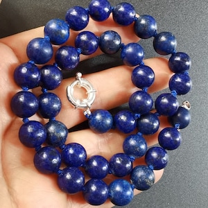 May include: A necklace made of dark blue lapis lazuli beads with a silver clasp.
