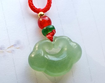 May include: A green jade pendant shaped like a cloud with a red and green beaded cord.