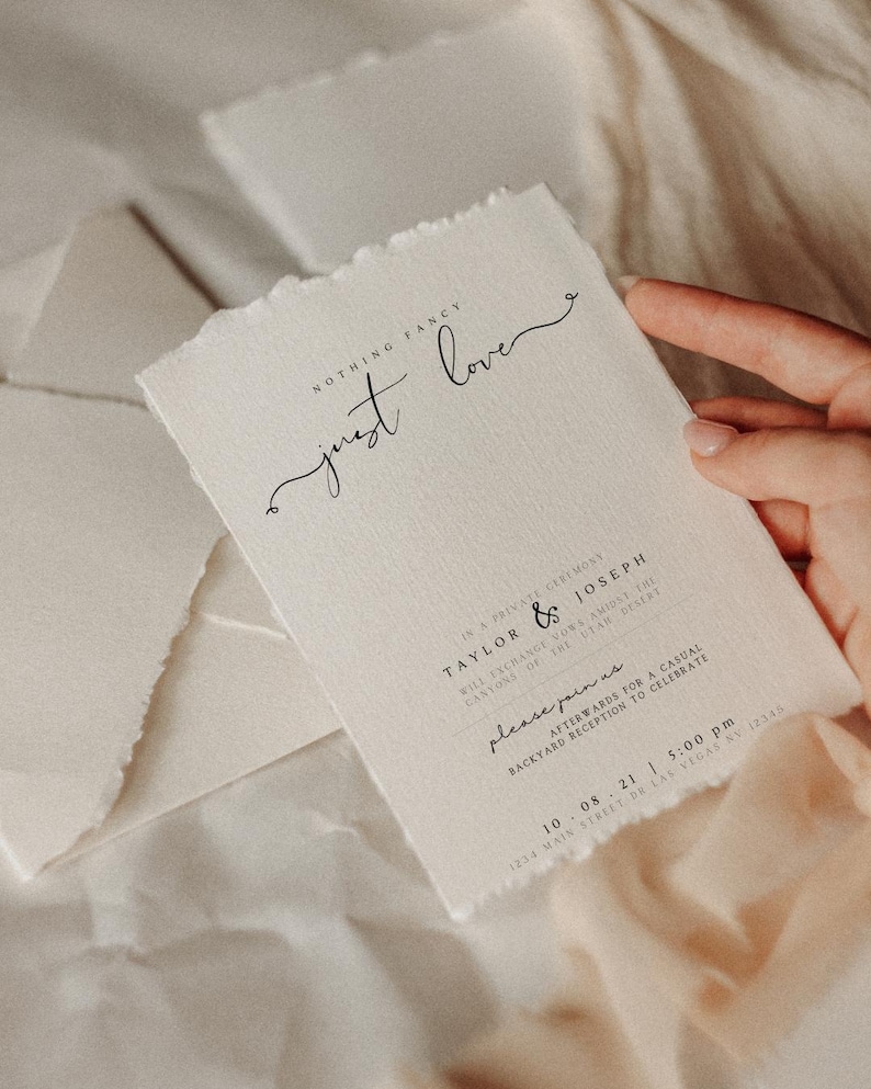 May include: A wedding invitation with a rustic, handmade paper texture. The invitation features the text "NOTHING FANCY just love" in a handwritten font. The invitation details a private ceremony for Taylor & Joseph on October 8th, 2021 at 5:00 PM. The address is 1234 Main Street, Las Vegas, NV 12345.