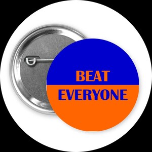 May include: A round button pin with a blue and orange design. The top half is blue, and the bottom half is orange. The text "BEAT EVERYONE" is in orange letters. The pin has a silver metal backing.