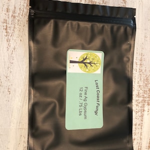 May include: A black resealable bag with a white label that says "Lost Coast Fungi" and "Fine Ag Gypsum 12 oz / .75 Lbs".