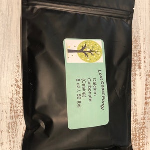 May include: A black resealable bag with a white label that says "Lost Coast Fungi" and "Calcium Carbonate (Casing) 8 oz / 50 lbs".