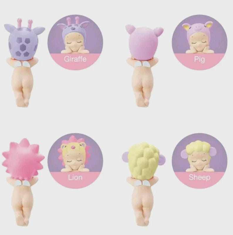 Op de afbeelding: Vier kleine babyfiguurtjes met dierenthema hoofddeksels, waaronder een paarse giraf, een roze varken, een roze leeuw en een geel schaap. Elk figuurtje heeft kleine witte vleugels op de rug en wordt van achteren getoond, met ronde inzetstukken die het vooraanzicht van elk personage tonen met de labels Giraffe, Pig, Lion en Sheep.