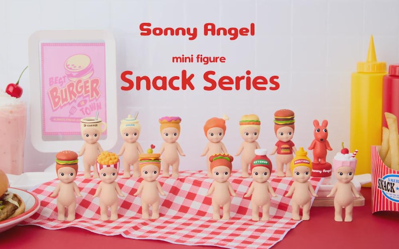 May include: A collection of Sonny Angel mini figures from the Snack Series. Each figure is nude with a different food-themed hat, including burgers, fries, and ice cream. The figures are arranged on a red and white checkered cloth.