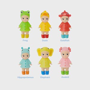 May include: Six small figurines dressed as animals: a frog, duck, goldfish, hippopotamus, elephant, and axolotl. Each figure wears a matching outfit and boots. The names of the animals are written below each figure.