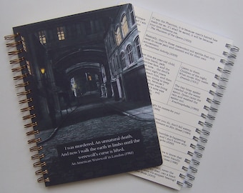 May include: A black and white spiral bound notebook with a dark gray cover featuring a photo of a narrow, cobblestone alleyway at night. The cover also includes a quote from the movie "An American Werewolf in London (1981)": "I was murdered. An unnatural death. And now I walk the earth in limbo until the werewolf's curse is lifted."