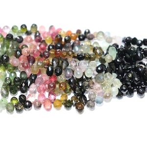 Puede incluir: Una hebra de cuentas de piedras preciosas facetadas en varios colores, incluyendo rosa, verde, negro y marr&oacute;n. Las cuentas tienen forma de l&aacute;grima y tienen un acabado brillante.