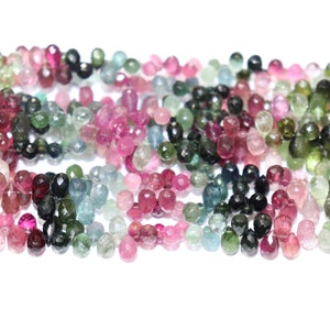 Puede incluir: Una hebra de cuentas de piedras preciosas facetadas en varios tonos de rosa, verde y azul. Las cuentas son todas aproximadamente del mismo tama&ntilde;o y tienen un acabado liso y pulido.