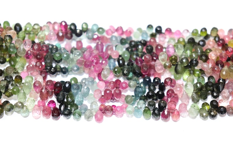 Puede incluir: Una hebra de cuentas de piedras preciosas facetadas en varios tonos de rosa, verde y azul. Las cuentas son todas aproximadamente del mismo tama&ntilde;o y tienen un acabado liso y pulido.