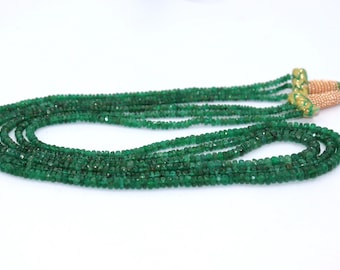 Pode incluir: Um colar de várias voltas composto por pequenas contas de esmeralda facetadas. As contas são de uma cor verde profunda e rica e são enfiadas para criar um design fluido e elegante. O colar tem um fecho dourado.