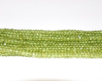 May include: A strand of light green peridot beads. The beads are faceted and have a round shape.