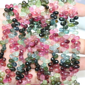 Puede incluir: Una hebra de cuentas de piedras preciosas multicolores. Las cuentas son facetadas y tienen forma de l&aacute;grima. Los colores incluyen rosa, verde, azul y negro.