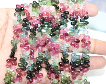 Peut inclure: Un brin de perles de pierres précieuses multicolores. Les perles sont facettées et ont une forme de goutte. Les couleurs comprennent le rose, le vert, le bleu et le noir.