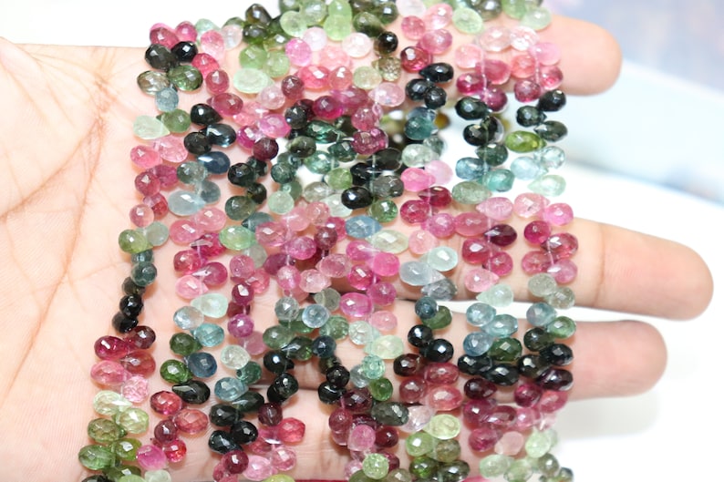 Puede incluir: Una hebra de cuentas de piedras preciosas multicolores. Las cuentas son facetadas y tienen forma de l&aacute;grima. Los colores incluyen rosa, verde, azul y negro.