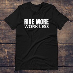 Puede incluir: Camiseta negra con texto blanco que dice "Ride More Work Less".