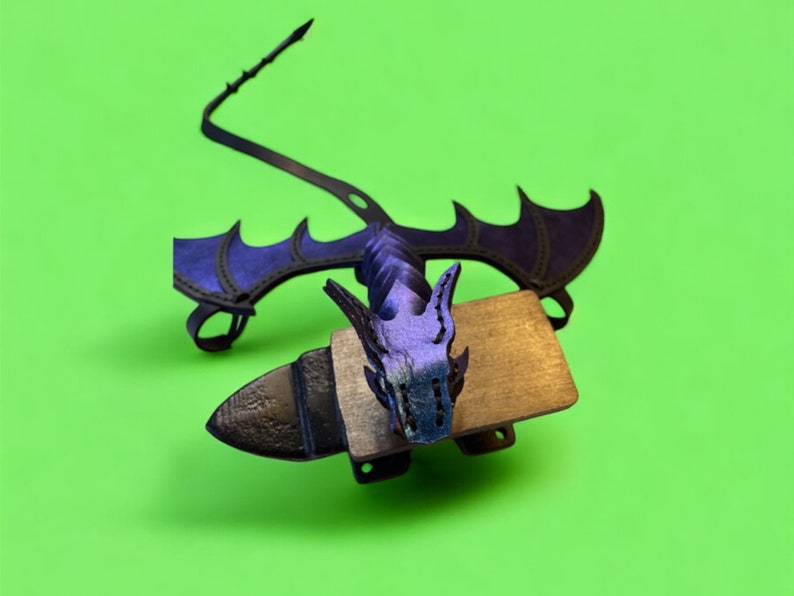 May include: A black and purple dragon figurine with wings, a tail, and a head with a textured design. The dragon is mounted on a wooden base.