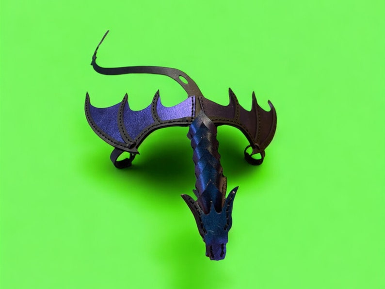 May include: A black leather dragon costume with purple wings. The dragon has a long tail and a pointed head.