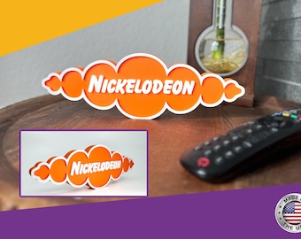 May include: Orange and white 3D printed Nickelodeon logo. The logo is shaped like a cloud with the word "Nickelodeon" in white letters.