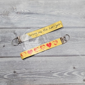May include: Yellow lanyard with red hearts and the text "bring me the horizon" written in black.