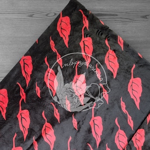 May include: Black fabric with a repeating pattern of red leaf shapes.