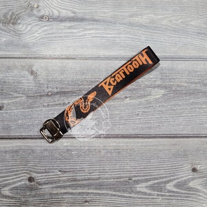 May include: Black and orange key chain with the text "Beartooth" and a snake design.