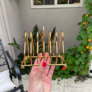 Puede incluir: Porta servilletas de metal dorado con seis ranuras para guardar servilletas. El porta servilletas est&aacute; hecho de metal delgado y tiene un dise&ntilde;o simple.