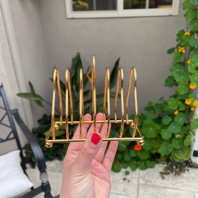 Puede incluir: Porta servilletas de metal dorado con seis ranuras para guardar servilletas. El porta servilletas est&aacute; hecho de metal delgado y tiene un dise&ntilde;o simple.