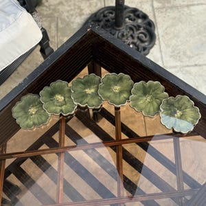 Peut inclure: Ensemble de six sous-verres floraux verts et dor&eacute;s. Les sous-verres sont en r&eacute;sine et ont un aspect unique et fait main. Ils sont parfaits pour ajouter une touche d'&eacute;l&eacute;gance &agrave; n'importe quelle maison.