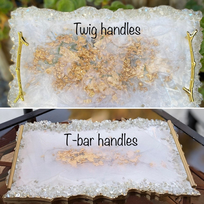 May include: Two white resin serving trays with gold accents. The top tray has twig handles and the bottom tray has T-bar handles. Both trays have a white background with gold flecks.