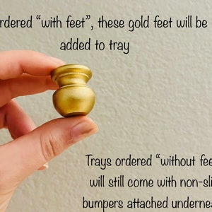May include: A gold metal tray foot. If ordered with feet, these feet will be added to the tray. Trays ordered without feet will still come with non-slip bumpers attached underneath.