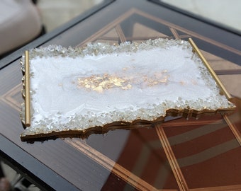 May include: A white resin serving tray with a gold rim and gold leaf accents. The tray has a rough, textured edge that resembles crystals.