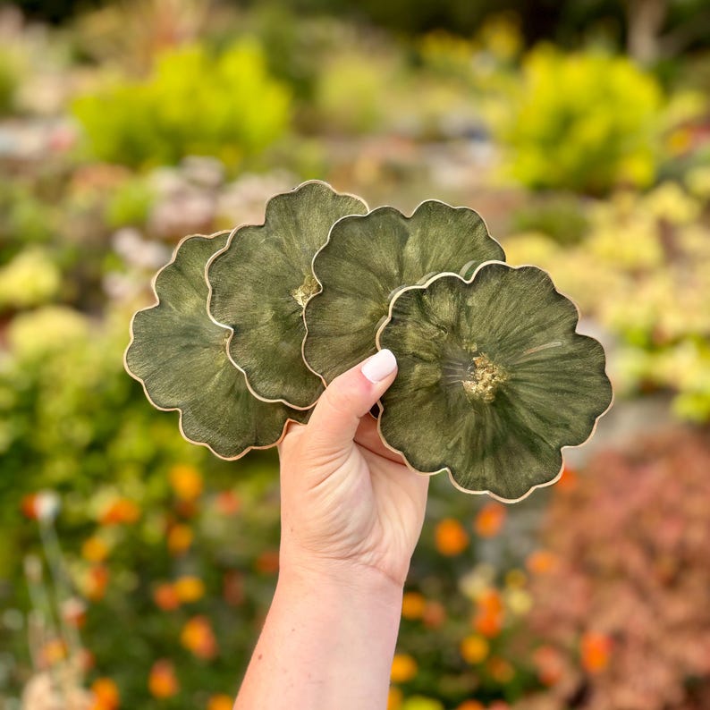 Peut inclure: Ensemble de quatre sous-verres en r&eacute;sine verte et dor&eacute;e &agrave; effet marbr&eacute;. Les sous-verres sont en forme de fleur avec un bord festonn&eacute;.