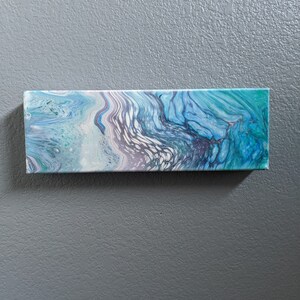 May include: Abstract painting on canvas with swirling blue, green, and white colors. The painting has a textured surface and a modern style.