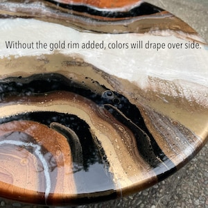 Op de afbeelding: Close-up van een rond, kunstig harswerk met een draaiende patroon van zwart, wit, goud en bruin. De tekst "Without the gold rim added, colors will drape over side." is zichtbaar bovenaan de afbeelding.
