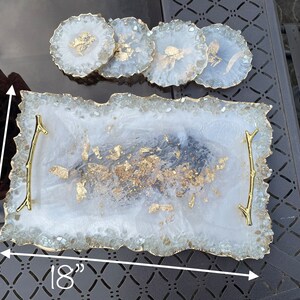 May include: White serving tray with gold accents and a gold twig handle. The tray is 18 inches long and 11 inches wide.