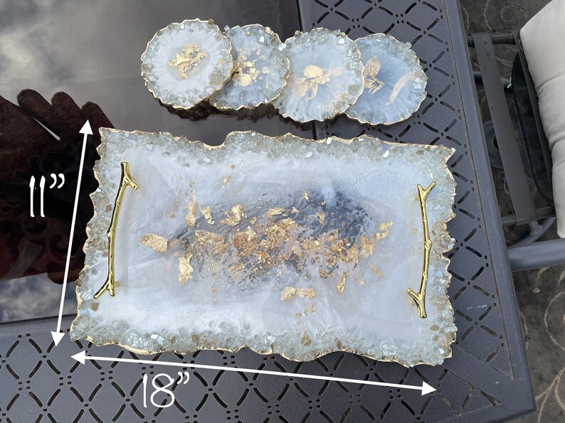 May include: White serving tray with gold accents and a gold twig handle. The tray is 18 inches long and 11 inches wide.