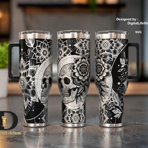 May include: Three black stainless steel tumblers with intricate white floral and skull designs. Each tumbler has a black handle and a silver rim. The design includes the text "Designed by: DigitalLifeStore SVG".