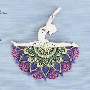 Puede incluir: Una silueta blanca de una persona en una postura de yoga, con las piernas extendidas y los brazos levantados por encima de la cabeza. La silueta está colocada sobre un mandala colorido con tonos de verde, azul y morado.