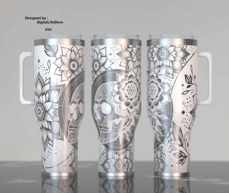 May include: Three white stainless steel tumblers with intricate black and gray floral and skull designs. Each tumbler has a handle and a silver rim. The text "Designed by: DigitalLifeStore SVG" is visible.