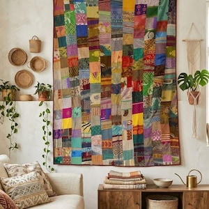 Könnte beinhalten: Ein großer rechteckiger Wandbehang-Quilt, der aus zahlreichen vertikalen Stoffstreifen in einer Vielzahl von Farben und Mustern besteht, darunter Blau-, Grün-, Gelb-, Rosa- und Violetttöne, mit durchgehend sichtbaren Nähten auf der Oberfläche.