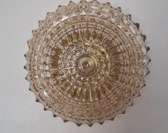May include: A gold-toned glass ceiling light fixture with a geometric pattern. The light fixture has a round shape and a textured surface.