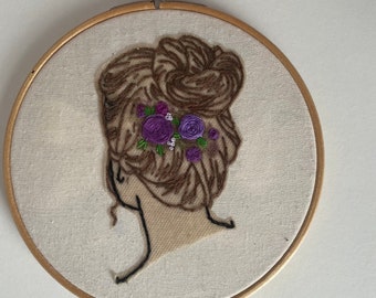 Embroidery hoop of feminine girl is with beautiful flowers in her hair